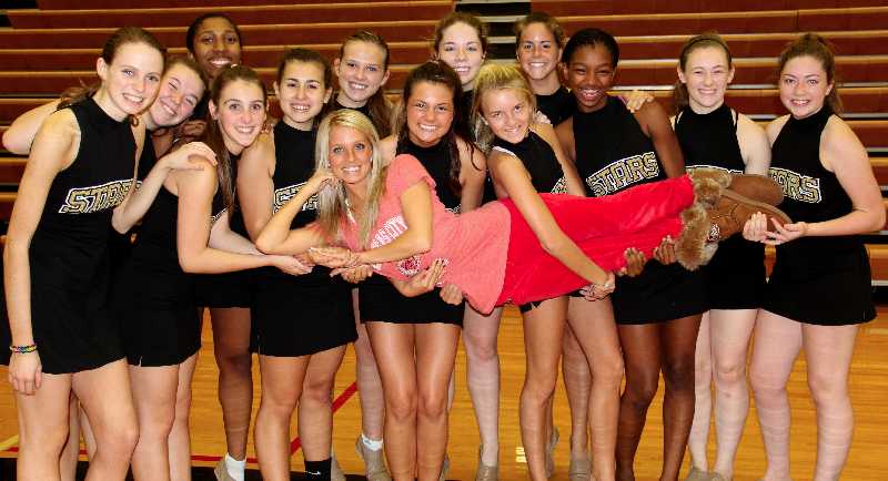 The STA varsity dance team girls hold up their coach and Kansas City Chief's Cheerleader Christina Monaco.