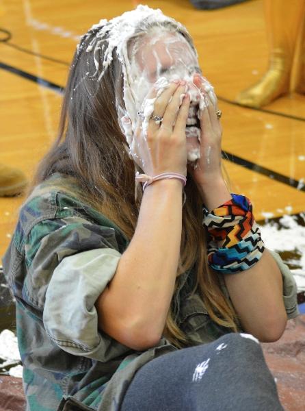 Senior Audrey Muehlebach wipes her face after senior Erin Farmer shoves a plate full of whipped cream in her face. Four of the musical members had whip cream all over their hair and faces.