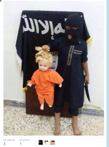Child outfitted in typical ISIS garb beheads a doll. 